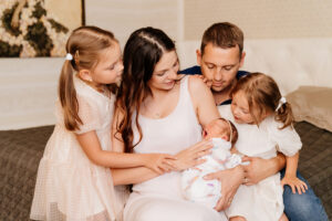 a happy family with many children. the first day at home of the newborn daughter